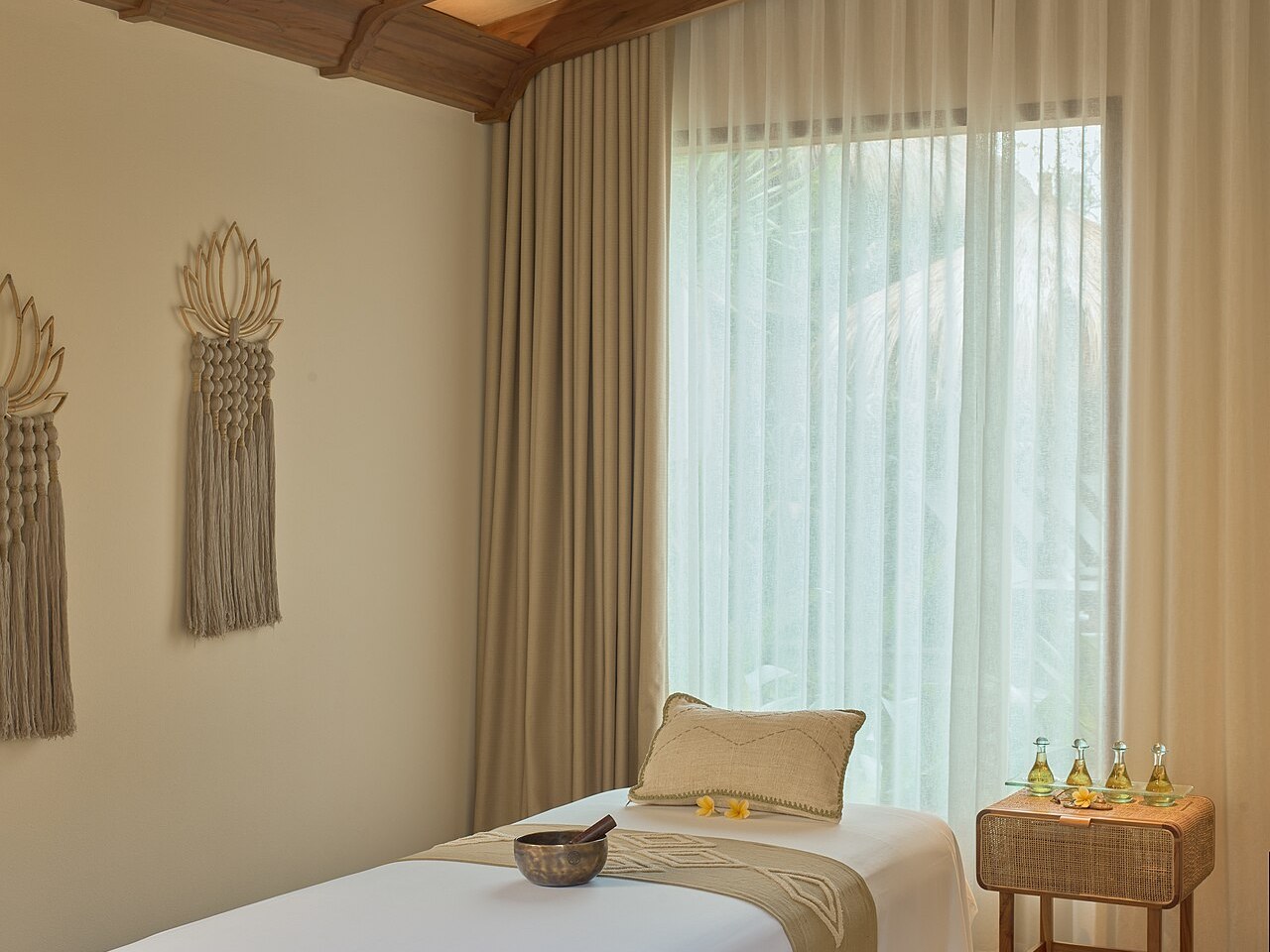 Massage treatment bed prepared with a singing bowl and oils